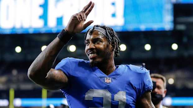 Tracy Walker raises his hands to waive at the crowd while walking off the field after a game.